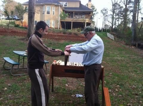 Grandfather and grandson tending the hive together in Georgia