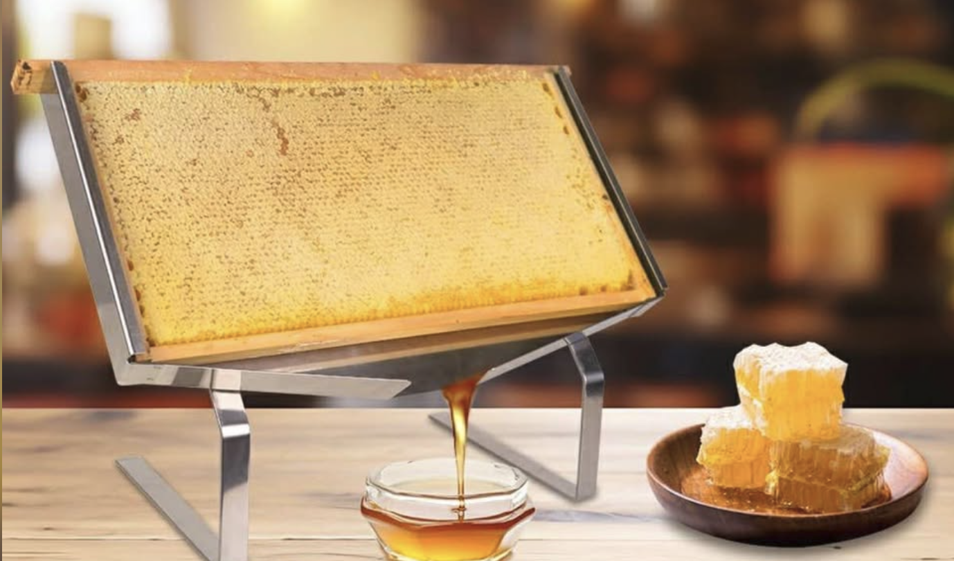 Raw honeycomb frame on a stand dripping honey