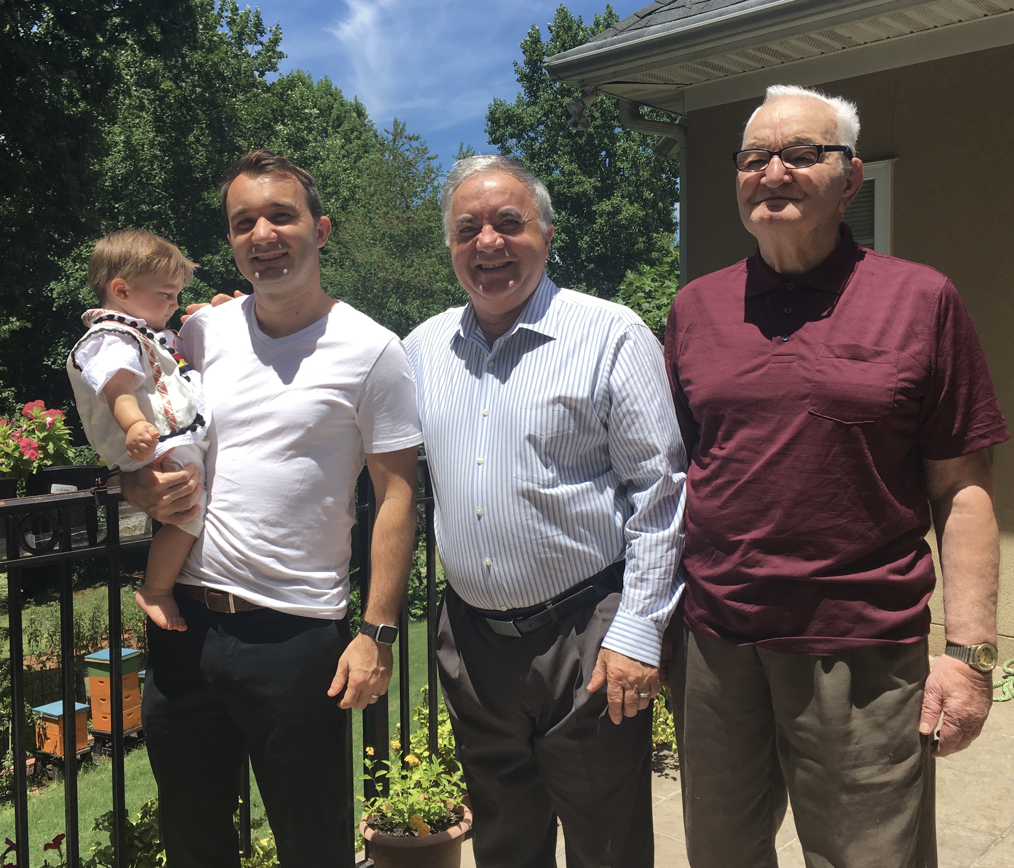 Four generations of the family together, with the beehives in the background
